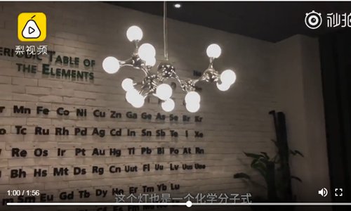 The cafe has a periodic table of elements on the wall and ceiling lamps are designed to represent a molecular structure. (Screenshot photo/Pear Video)