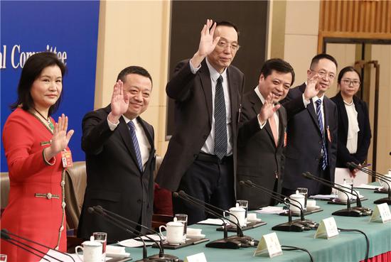 From left: Political advisers Zhou Qunfei, Ye Qing, Liu Shijin, Nan Cunhui and Zhou Hongyi wave to journalists at a news conference held during the ongoing session of the 13th National Committee of the Chinese People's Political Consultative Conference in Beijing, March 6, 2019. （Photo/China Daily）