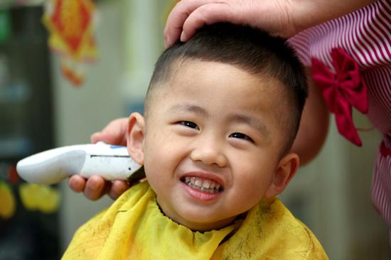 A Chinese boy has his hair cut to celebrate Longtaitou Festival, also known as the Dragon-Head-Raising Festival, in Zaozhuang city, East China's Shandong Province, March 8, 2019. (Photo/Xinhua)