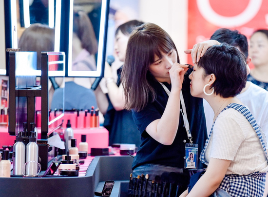 A consumer tries cosmetics at a shopping mall in Beijing. (Photo by Niu Jing/For China Daily)