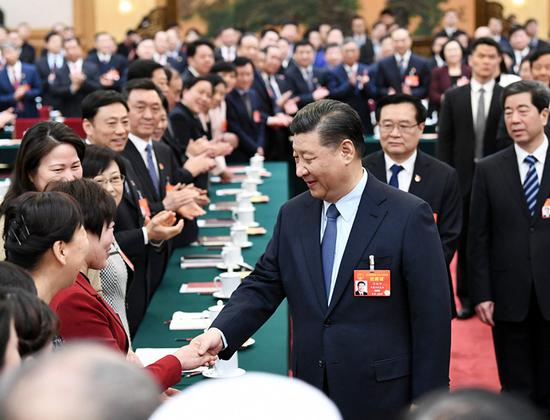 President Xi Jinping extends greetings for International Women’s Day to deputies of the National People’s Congress during his visit to the Henan delegation in Beijing on Friday. (XIE HUANCHI) 