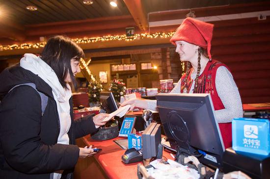 A customer pays by using Alipay in a shop in Rovaniemi, Finland. (Photo provided to China Daily)