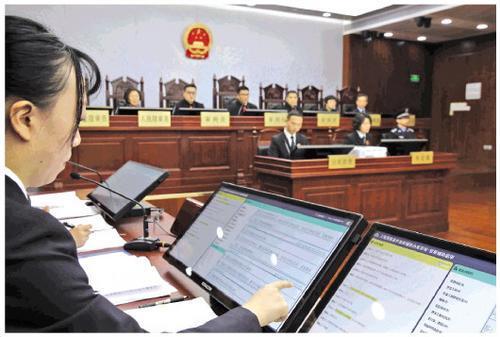 A public prosecutor reviews evidence presented by the AI system during a hearing at a Shanghai court on Wednesday, January 23, 2019. [File photo: Legal Daily]