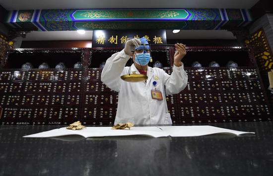 A pharmacist weighs herbs at a drugstore of Tongrentang, a pharmaceutical company with a history of more than 300 years, in Beijing, capital of China, Oct. 25, 2018. (Xinhua/Zhang Chenlin)