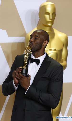 Former U.S. basketball player Kobe Bryant poses after winning the Best Animated Short Award for 