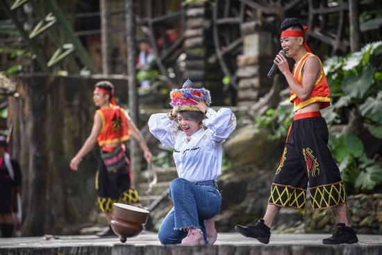 A visitor participates in a performance featuring customs of the Li and Miao ethnic groups in Hainan province in January. (Photo: For China Daily/Yuan Chen)