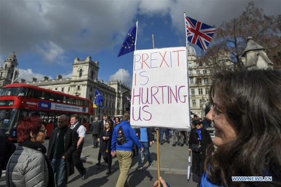 An anti-Brexit protester holds a placard outside the Houses of Parliament in London, Britain, on March 19, 2019. (Xinhua/Stephen Chung)