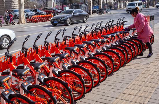 A worker organizes Mobike shared bicycles in Jinan, Shandong province, on Friday.(Photo/China Daily)