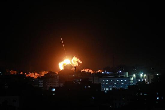 Photo taken on March 25, 2019 shows flame and smoke above buildings following an Israeli air strike in Gaza City. The Israeli army expanded air strikes on the Gaza Strip on Monday night after targeting Hamas security facilities in Gaza City, a local radio station and eyewitnesses said. (Xinhua/Stringer)