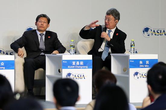 Zhu Min, chair of the National Institute of Financial Research at Tsinghua University (right), speaks during a panel discussion at the 2019 Boao Forum for Asia Annual Conference in Boao, Hainan province, on Friday. (Photo by Wang Zhuangfei / China Daily)