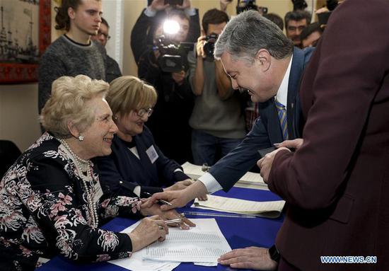 Ukraine's incumbent President Petro Poroshenko (R) prepares to cast his ballot at a polling station in Kiev, Ukraine, March 31, 2019. Voting for the presidential election in Ukraine kicked off on Sunday with a record number of 39 candidates competing for the presidency. (Xinhua/Ukrainian Presidential Press Service)