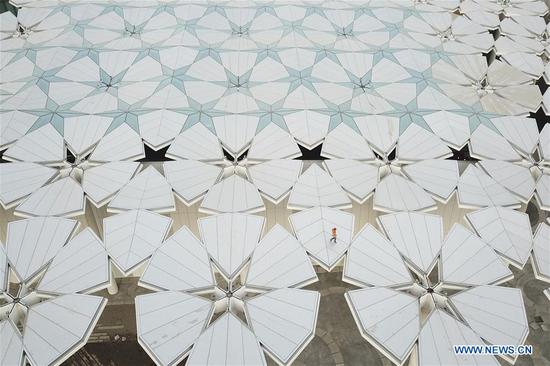 Aerial photo taken on March 26, 2019 shows a worker walking on the roof of the International Pavilion at the site of the International Horticultural Exhibition 2019 Beijing China (Expo 2019 Beijing) in Yanqing district of Beijing. (Photo/Xinhua)
