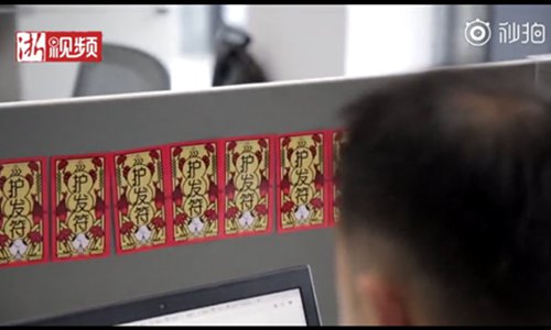 Small stylized posters or blessing paper are hung in the office to protect employees from going bald. (Screenshot photo/Zhejiang Daily)