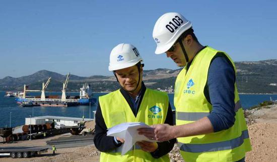 Chinese engineer Zhang Fei (L) and Croatian engineer Ivica Granic, both employees of China Road and Bridge Corporation (CRBC), read construction plan at Peljesac Peninsula, Croatia, March 21, 2019. /Xinhua Photo