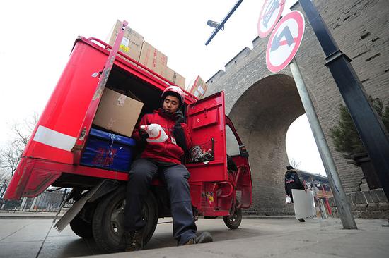 A JD deliveryman gets ready to make deliveries in Jinzhong, Shanxi province. [Provided to China Daily]