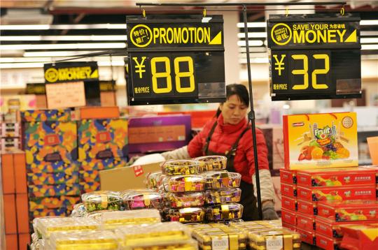 A saleswoman arranges imported snacks at a duty-free store in Qingdao, Shandong province. (Photo/Xinhua)