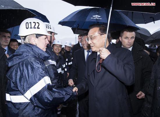 Chinese Premier Li Keqiang (R, front) talks with technicians at the construction site of Peljesac Bridge being built by a Chinese consortium, during a visit with his Croatian counterpart Andrej Plenkovic on the Peljesac Peninsula in southern Croatia, April 11, 2019. (Xinhua/Huang Jingwen)