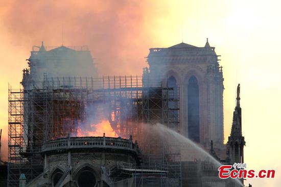 Firefighters work near the Notre Dame Cathedral in central Paris, capital of France, on April 15, 2019. A blaze broke out on Monday afternoon at the Notre Dame Cathedral in central Paris. (Photo/China News Service)