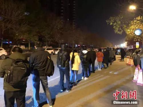 Office workers line up to get on a bus on the early morning in Beijing. (File photo/China News Service)