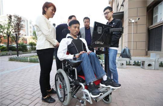 Zhang Wei operates the wheelchair at a residential community in Xi'an, Shaanxi province, April 17, 2019. （Photo by Chen Feibo/For chinadaily.com.cn）