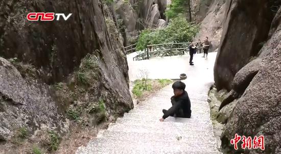 Disabled Li Chuangye climbs Mount Huangshan with his hands in Anhui Province. (Photo/Screenshot on CNSTV)