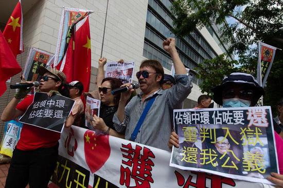 Residents carry placards to support jail sentences for leaders of the illegal 