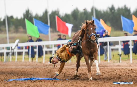 A man picks up a hada when riding a horse during the Genghis Khan Chagan Suluk Nadam Fair in Ejin Horo Banner of Ordos City, north China's Inner Mongolia Autonomous Region, April 24, 2019. The two-day fair kicked off on Wednesday, including a variety of traditional activities. (Xinhua/Peng Yuan)