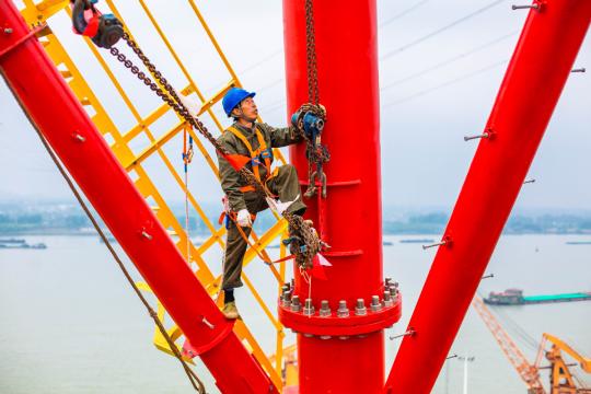 An electrician checks power transmission facilities in Zhenjiang, Jiangsu province. (Photo by Tang Dehong/For China Daily)