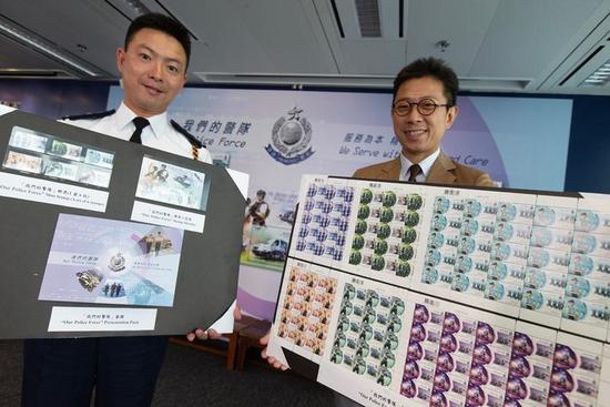 Hong Kong Post's Senior Manager (Philatelic Marketing) Nelvin Lee (R) and Chief Drill and Musketry Inspector Lo Yee-chung pose with 