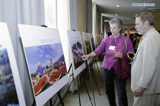 People watch a photo exhibition during a tourism promotion event featuring China's Mount Huangshan at the UN headquarters in New York, on May 3, 2019. China's Mount Huangshan, also known as Yellow Mountain, was promoted Friday at the United Nations headquarters in New York, as part of its efforts to work its way into the international market. (Xinhua/Li Muzi)