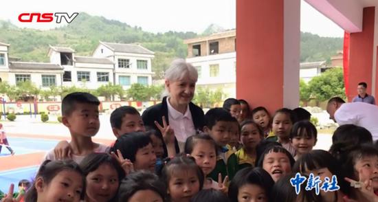 German sinologist and writer Petra Haering-Kuan  poses for a group photo with children from Pingtang, Guizhou Province. (Photo/Screenshot on CNSTV)