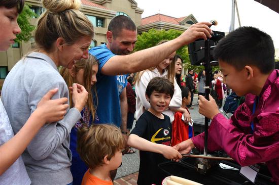 Visitors experience the traditional Chinese musical instrument erhu at an event hosted by the Chinese embassy in the United States in Washington on Saturday. （Photo: China News Service/Chen Mengtong）