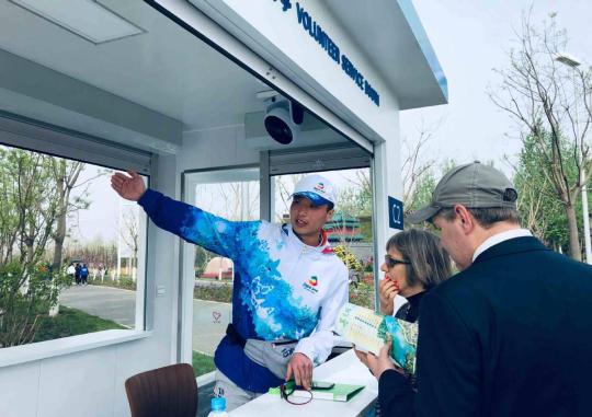 Xu Qing, a volunteer, directs foreign visitors at the Beijing Horticulture Expo park in April. (JIN DAN/CHINA DAILY)