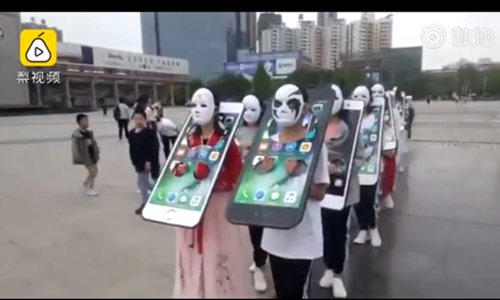 Students' heads and arms are in a pillory in the shape of mobile phones. (Screenshot photo/Pear Video)