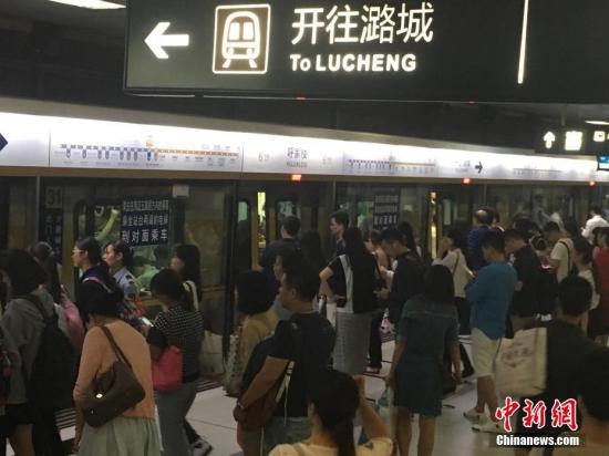 Passengers wait to get on a subway train in Beijing. (File photo/China News Service)