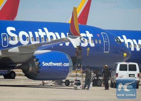 People work on a Southwest Airlines Boeing 737 Max aircraft at the Southern California Logistics Airport, also known as Victorville Airport, in Victorville, California, the United States, on March 27, 2019. (Xinhua/Zhao Hanrong)