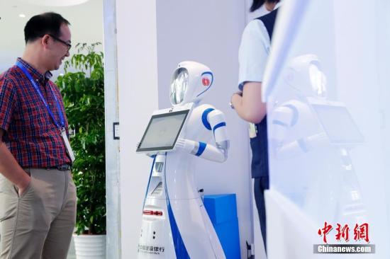 A robot communicates with a man. (File photo/China News Service)