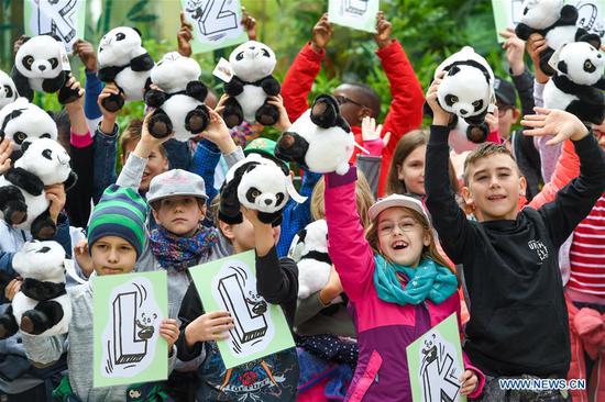Children wave panda toys to welcome giant panda Yuan Yuan at the Schoenbrunn Zoo in Vienna, Austria, on May 20, 2019. Giant panda Yuan Yuan was officially handed over to the zoo in a grand ceremony on Monday morning. Yuan Yuan is a 19-year-old male who has been in Vienna since mid-April and quarantined for a month before visitors could take a look at him. (Xinhua/Guo Chen)