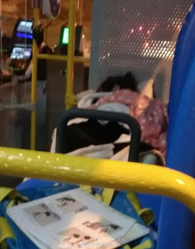 A little girl, about four to five years old, was seen lying asleep on a bus seat with a quilt, pillow and books, on May 21, 2019. (Photo from Weibo)