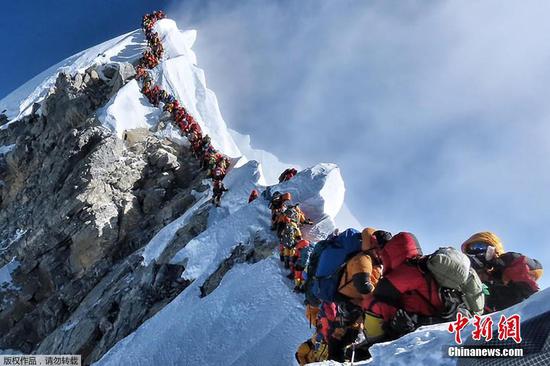 A crowd of mountaineers waits their turn to stand on the summit of Qomolangma in a photo taken on May 22. (Photo/Agencies)
