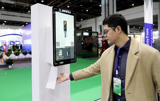 An exhibitor shows an automatic tissue paper distributor with face detection at the 2018 Chinese Toilet Revolution Innovation Expo in east China's Shanghai, Nov. 18, 2018. (Xinhua/Fang Zhe)