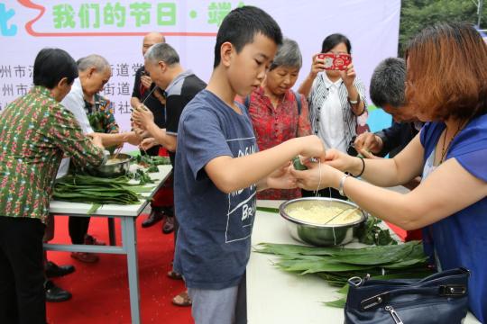 Youngsters learn to make zongzi (rice dumplings) in Luzhou city, Sichuan province. XINHUA