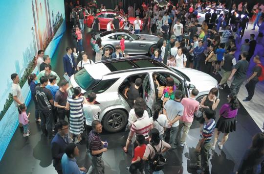 Visitors examine cars at the 2019 Shenzhen-Hong Kong-Macao International Auto Show held in Shenzhen, Guangdong Province in early June. (Photo provided to China Daily)
