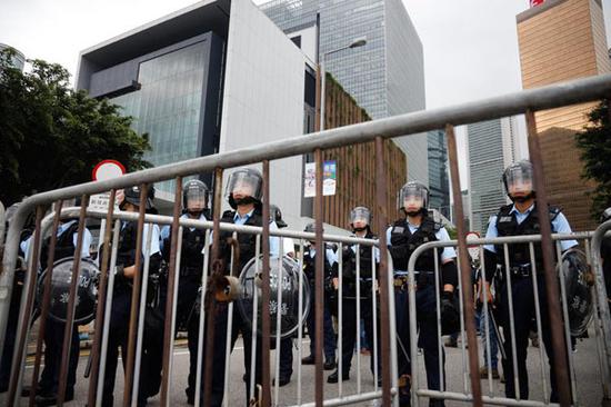 Police officers take up position outside the Office of the Chief Executive in Hong Kong on June 12, 2019. (Photo by ROY LIU / CHINA DAILY)