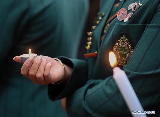 Students light candles to mourn victims during a mourning ceremony near the attack site in Christchurch, New Zealand, March 18, 2019. (Xinhua/Guo Lei)