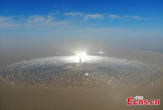 A view of a 100-megawatt molten-salt solar thermal power plant in Dunhuang City, Northwest China's Gansu Province, Dec. 26, 2018. The plant is powered by 12,000 mirrors that concentrate sunlight onto a receiver at the top of a solar tower, 260 meters high. The heat collected is used to create steam that turns a turbine and generator, as at a traditional thermal power plant. The molten salt can also be stored and used to generate power on demand, even at night. (Photo: China News Service/Yang Yanmin)