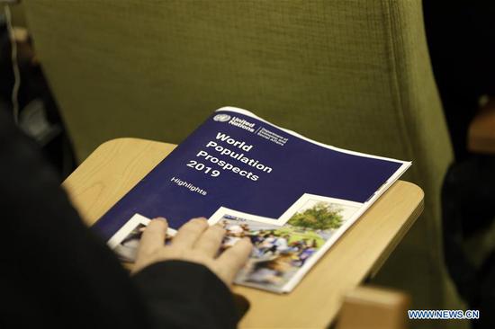A journalist holds a copy of the World Population Prospects 2019: Highlights, at the UN headquarters in New York, on June 17, 2019. The world's population is expected to increase by 2 billion in the next 30 years, from 7.7 billion currently to 9.7 billion in 2050, according to a United Nations report released here on Monday. (Xinhua/Li Muzi)