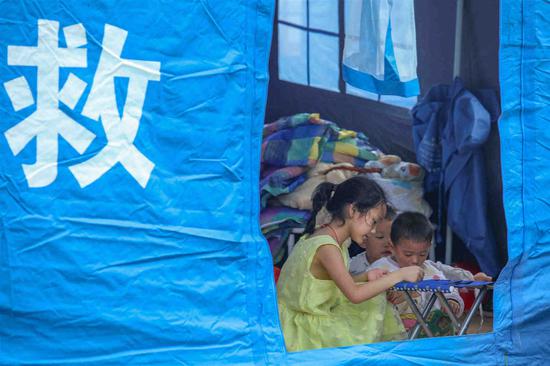 Children entertain themselves in a disaster relief tent on Tuesday in Shuanghe, a township in Changning county, Sichuan province, after an earthquake struck on Monday night. LIU CHANGSONG / FOR CHINA DAILY