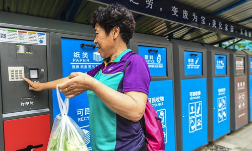 A woman uses the smart garbage classification facility in a residential community in Xianghe county, North China's Hebei Province on Tuesday. China has been stepping up efforts to build a national garbage sorting system in recent years. (Photo/Xinhua)