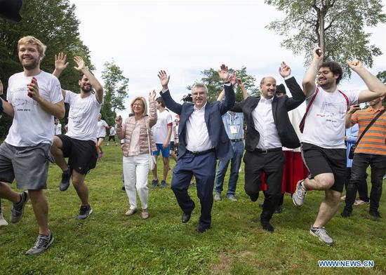 International Olympic Committee (IOC) President Thomas Bach (C) and Mayor of Lausanne Gregoire Junod (2nd R) react during the Olympic Day Run in Lausanne, Switzerland, June 22, 2019. (Xinhua/Xu Jinquan)